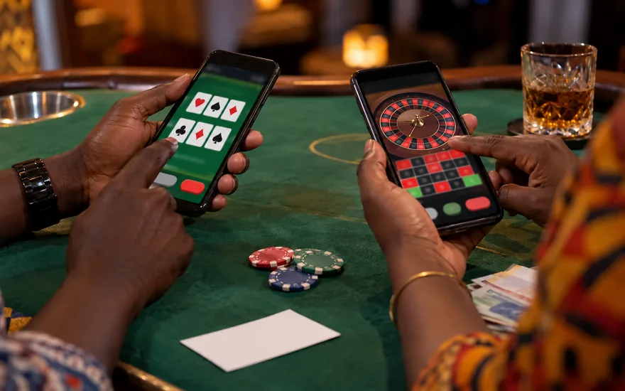 Best online casino comparison in Zambia with separate card and roulette screens on two phones beside plain gaming objects.