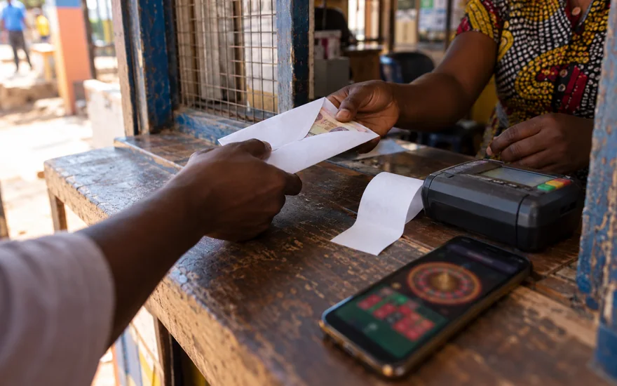 Fast withdrawal casino payment scene with a plain cash envelope and a roulette phone.