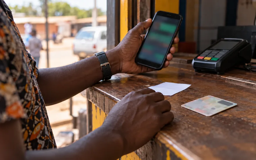Zambia casino guide privacy policy scene with a betting phone turned away beside an unreadable identity card, receipt and payment terminal.