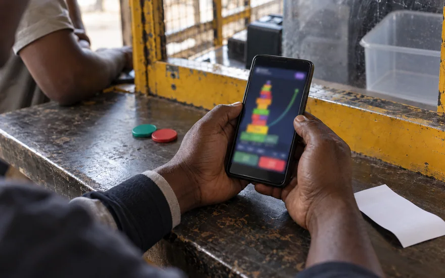 Tower Rush Zambia scene with an abstract stacked-block casino phone, blank betting receipt and unmarked chips in Zambia.