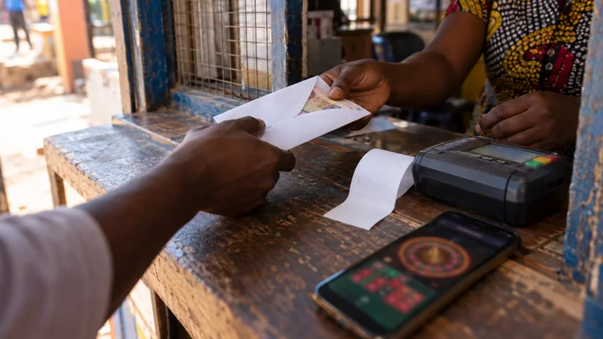 Fast withdrawal casino payment scene with a plain cash envelope and a roulette phone.