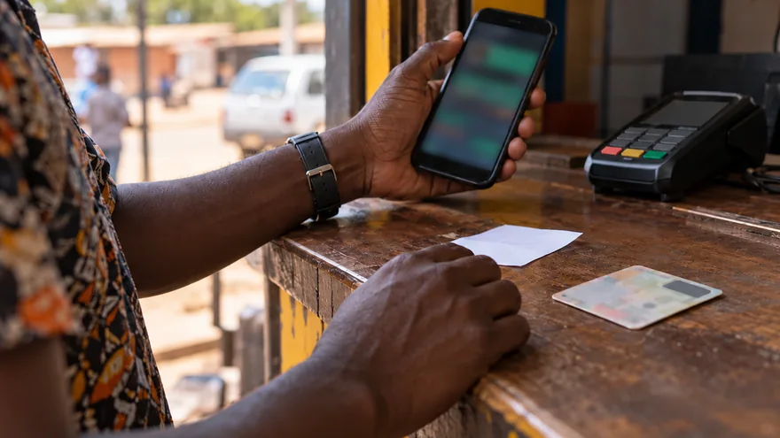 Zambia casino guide privacy policy scene with a betting phone turned away beside an unreadable identity card, receipt and payment terminal.